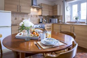 a kitchen with a wooden table with a bowl of fruit at Corner Cottage in Leyburn +9 photos