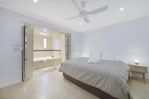 um quarto branco com uma cama e uma casa de banho em Logans Beach Apartments - BeachHouse em Warrnambool