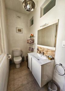 a bathroom with a toilet and a sink and a mirror at Dar Garigor in Cospicua