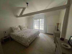 una camera bianca con un letto e una finestra di Belle demeure tourangelle 8 prs a Sorigny