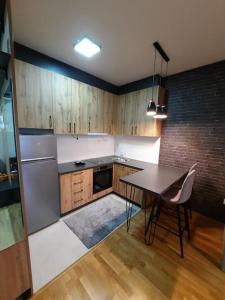 uma cozinha com uma mesa e um frigorífico em Cozy one-bedroom apartment in Skopje em Skopje