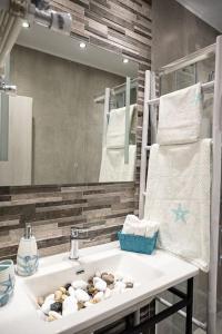 bagno con lavandino bianco e specchio di Ammos Lux Apartments a Agia Triada