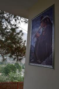 un tableau d'un homme avec un pistolet suspendu sur un mur dans l'établissement Chitral Green Guest House, à Chitral