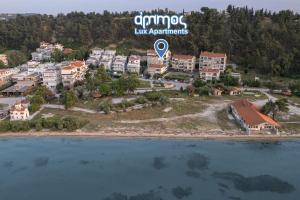 una vista aerea di un resort su un'isola in acqua di Ammos Lux Apartments a Agia Triada