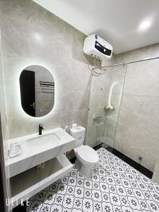 y baño con lavabo, aseo y espejo. en Minh Homestay, en Thôn Lại Thê
