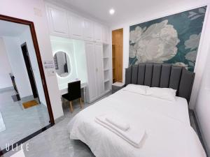 1 dormitorio con cama blanca y espejo en Minh Homestay, en Thôn Lại Thê