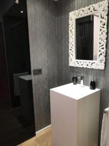 a bathroom with a sink and a mirror on the wall at LOS PUENTES casa con jacuzzi para 2 in Olmos de Peñafiel