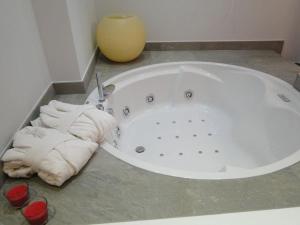 LOS PUENTES casa con jacuzzi para 2 في Olmos de Peñafiel: حوض استحمام أبيض مع مناشف على الأرض