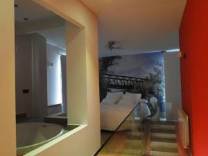 a living room with a bed and a spider on the wall at LOS PUENTES casa con jacuzzi para 2 in Olmos de Peñafiel