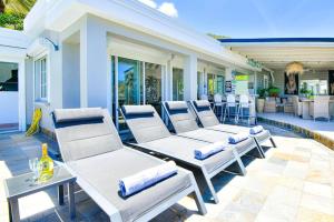un groupe de chaises blanches sur une terrasse dans l'établissement Villa Caraibe Sea 5 min walk to Orient Bay beach, à La Baie-Orientale