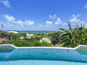 une piscine avec vue sur l'océan dans l'établissement Villa Caraibe Sea 5 min walk to Orient Bay beach, à La Baie-Orientale