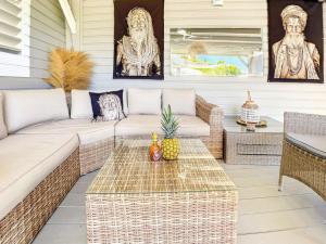 un patio avec un canapé et une table dans l'établissement Villa Caraibe Sea 5 min walk to Orient Bay beach, à La Baie-Orientale