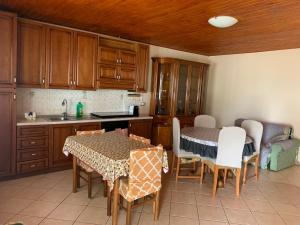 Casa vacanze Tilly في Pannaconi: مطبخ بدولاب خشبي وطاولة وكراسي