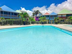 a swimming pool in front of some houses at Maison Caraibes beach front on Orient Bay with 2 big pools in Orient Bay