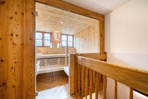 baño grande con paredes de madera y escalera de madera en Thorbäck Gut - Apartments im Schlosserhaus, en Öblarn