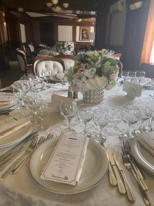 a table with plates and glasses and a vase of flowers at Cazare Plopii fara Sot in Iaşi