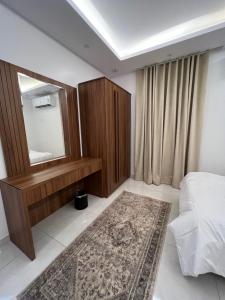 شقة بغرفتي نوم وصالة جلوس في المدينة المنورة: غرفة نوم مع مرآة وسرير وسجادة