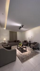 شقة بغرفتي نوم وصالة جلوس في المدينة المنورة: غرفة معيشة مع كنب وطاولة قهوة