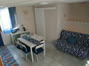 een woonkamer met een tafel en stoelen en een bank bij La spiaggetta di San Giovanni in Giardini Naxos