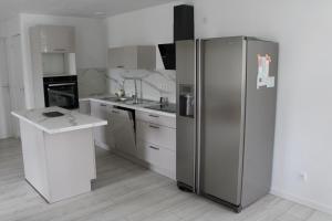 a kitchen with a stainless steel refrigerator and a counter at Chez Lili in Meslan