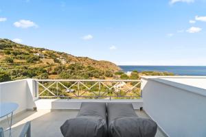 einen Balkon mit einem Sofa und Meerblick in der Unterkunft Seaside & Modern Flats near Chora in Steniaí