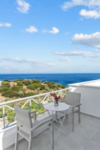 einen Balkon mit einem Tisch, Stühlen und Meerblick in der Unterkunft Seaside & Modern Flats near Chora in Steniaí