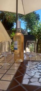 Una botella de alcohol sentada en una mesa con dos vasos. en Antheor cap Roux en Saint-Raphaël