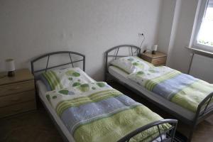 2 Einzelbetten in einem Zimmer mit Fenster in der Unterkunft Ferienwohnung Drieling, 85091 in Ostrhauderfehn