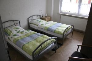 two twin beds in a room with a window at Ferienwohnung Drieling_ 85091 in Ostrhauderfehn