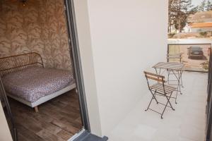 een kamer met een bed en een tafel en stoelen bij « La Casa Normande » entre Ville & Plages in Esquay-sur-Seulles