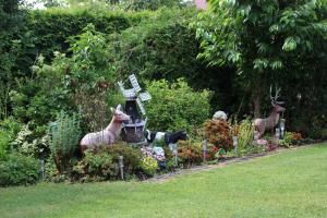 einen Garten mit einer Statue von Tieren in einem Garten in der Unterkunft Ferienwohnung Drieling, 85091 in Ostrhauderfehn