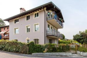 a white house with a balcony and bushes at GARDASUN 2 Lovely flat Lake close Pet friendly in Padenghe sul Garda
