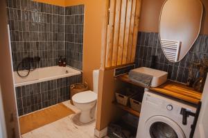 een badkamer met een wastafel, een toilet en een spiegel bij « La Casa Normande » entre Ville & Plages in Esquay-sur-Seulles