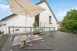 a patio with a table and an umbrella at Dachgeschoss Traum Schwelm Blüche in Schwelm