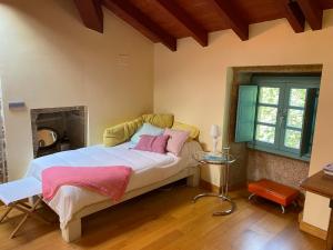 Un dormitorio con una cama con almohadas rosas. en Casa A Canella, en Sobreira