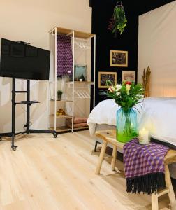 una camera da letto con TV e letto e un tavolo con fiori di Alte Scheune, Parken-WLAN-Küche-Bad-Tierlieb a Däniken