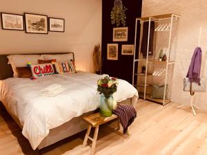 una camera da letto con un letto e un tavolo con un vaso di fiori di Alte Scheune, Parken-WLAN-Küche-Bad-Tierlieb a Däniken