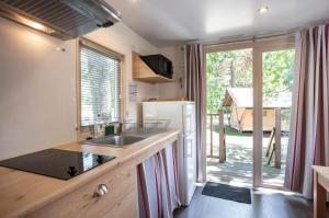 een keuken met een wastafel en een koelkast bij CityKamp Lyon in Dardilly