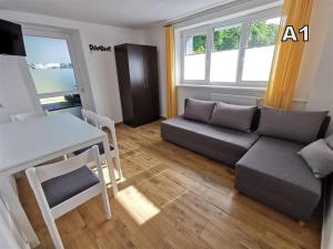 ein Wohnzimmer mit einem Sofa und einem Tisch in der Unterkunft DM APARTAMENTY Kościelna 54 in Mielno