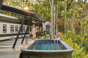 a man sitting in a hot tub next to a train at InterContinental Khao Yai Resort, an IHG Hotel in Mu Si