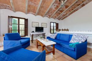 a living room with blue couches and a table at Finca Es Galliner in Felanitx