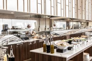 a restaurant kitchen with a chef preparing food at NissiBlu Beach Resort in Ayia Napa