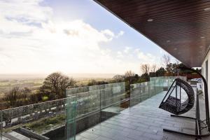 une maison en verre avec une balançoire sur le balcon dans l'établissement The Wylies, à Dunmurry
