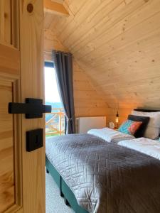 two beds in a room with a wooden ceiling at Ovis Homes I Gorąca balia - Widok na góry - 8 osób - Komfortowy domek in Zawoja +50 photos