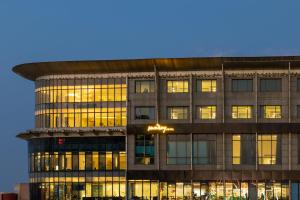 an office building with illuminated windows at dusk at Sunday Hotel Jaipur in Jaipur