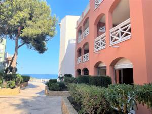 un edificio con un árbol al lado de la playa en Edison Bungalow LEK con aire, en Peñíscola