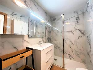 Un baño blanco con lavabo y ducha. en Edison Bungalow LEK con aire, en Peñíscola 20 fotos más