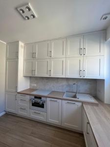 a kitchen with white cabinets and a sink at Gdynia Centrum ul. Pomorska in Gdynia