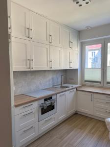 a kitchen with white cabinets and a sink and a window at Gdynia Centrum ul. Pomorska in Gdynia