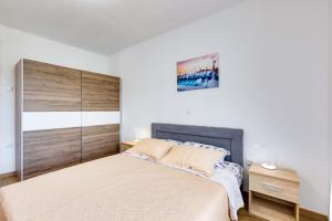 a bedroom with a large bed with a wooden headboard at Apartment Gržetić in Rasopasno